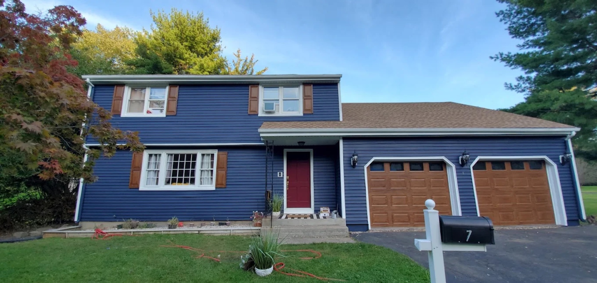 Exterior painting - blue colonial with wooden shutters in Connecticut