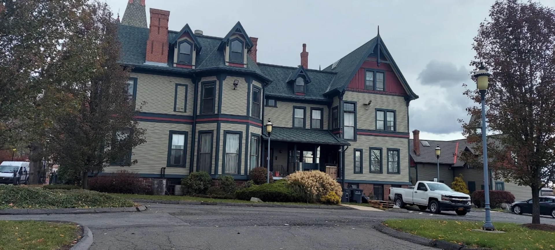Exterior painting - white farmhouse with red door and wrap-around porch CT
